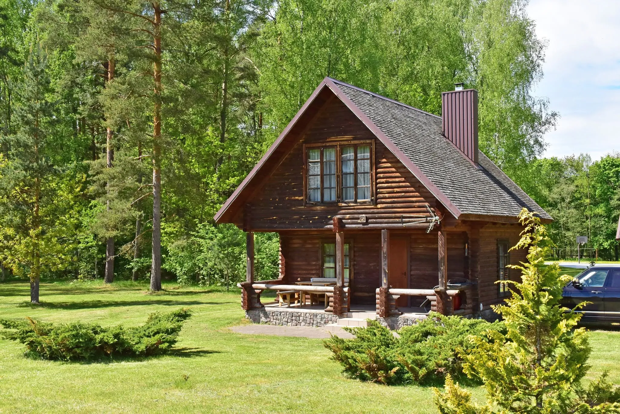 Rąstinis namelis tarp pušų
